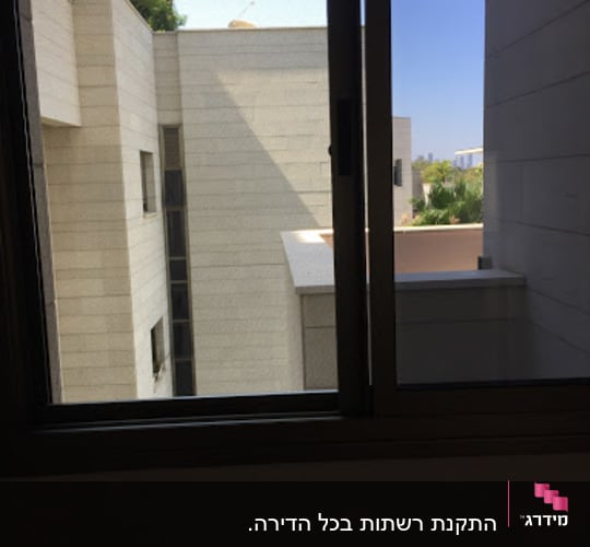 חלון אלומיניום פתוח עם נוף לבניינים חיצוניים